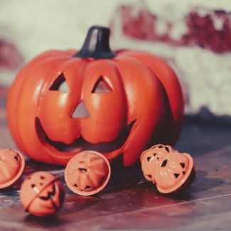 A jack-o-lantern with some small pumpkin shaped bells.